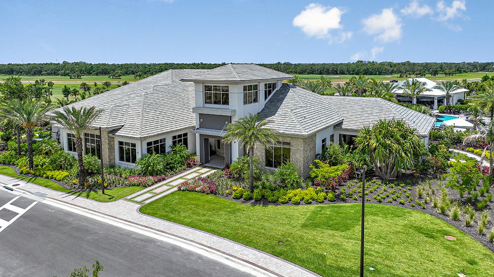 Modern large house with a gray roof and landscaped garden.