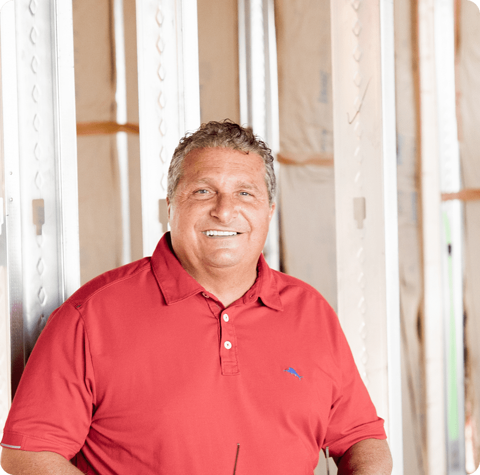Man in a red polo shirt smiling indoors.