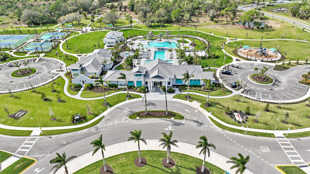 Aerial view of a luxurious mansion with a pool and manicured gardens.